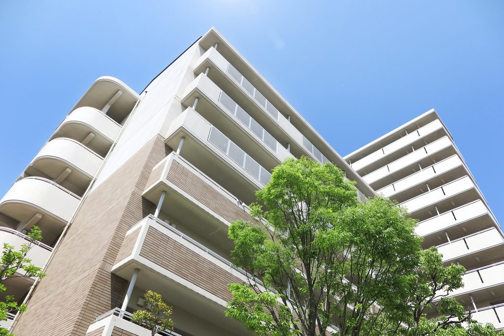 青空の下に建つマンションの外観
